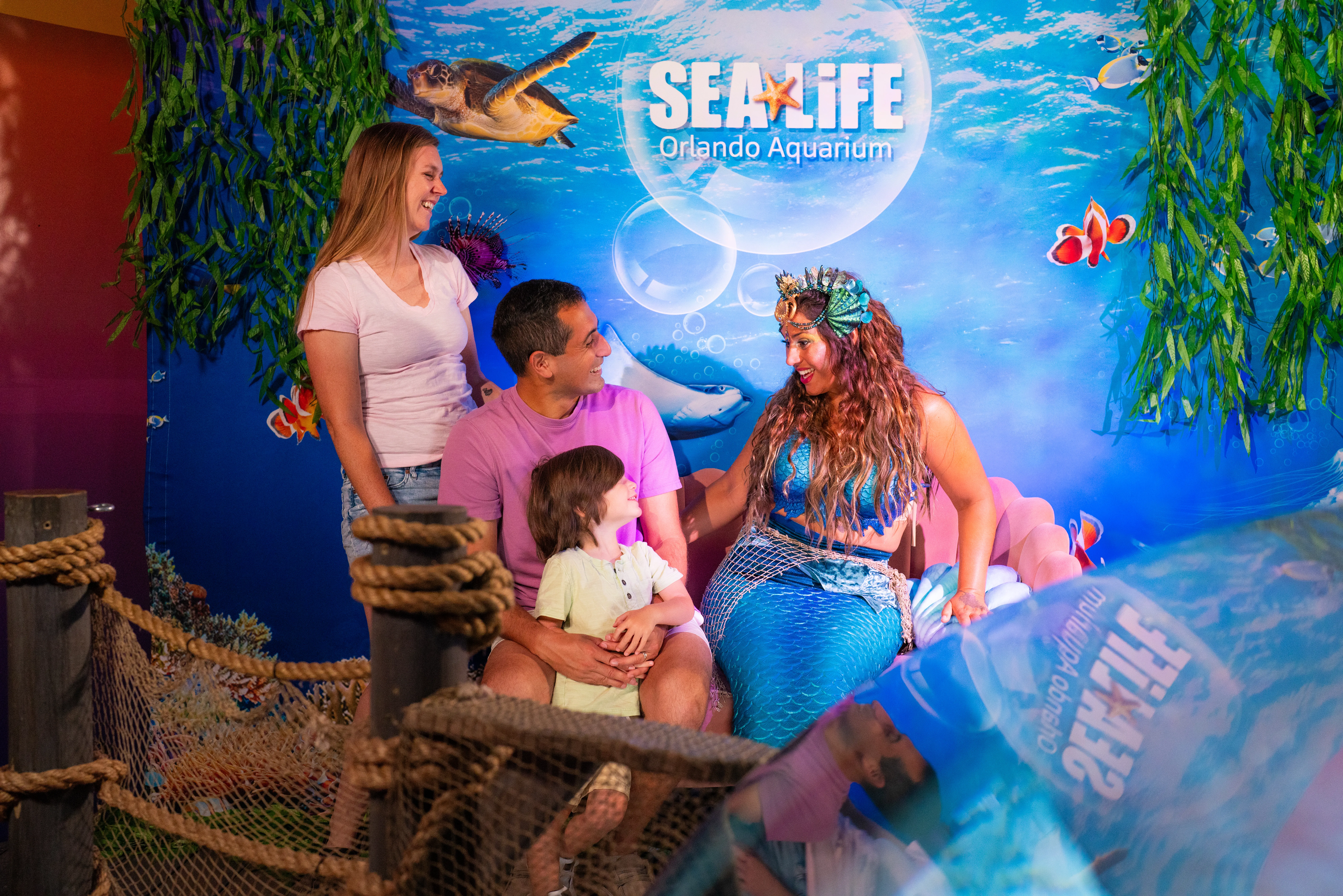 Family meeting a mermaid at SEA LIFE Orlando’s Mermaid Grotto.